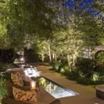 Modern landscaped backyard in Toronto with patio, decorative lighting, and lush greenery