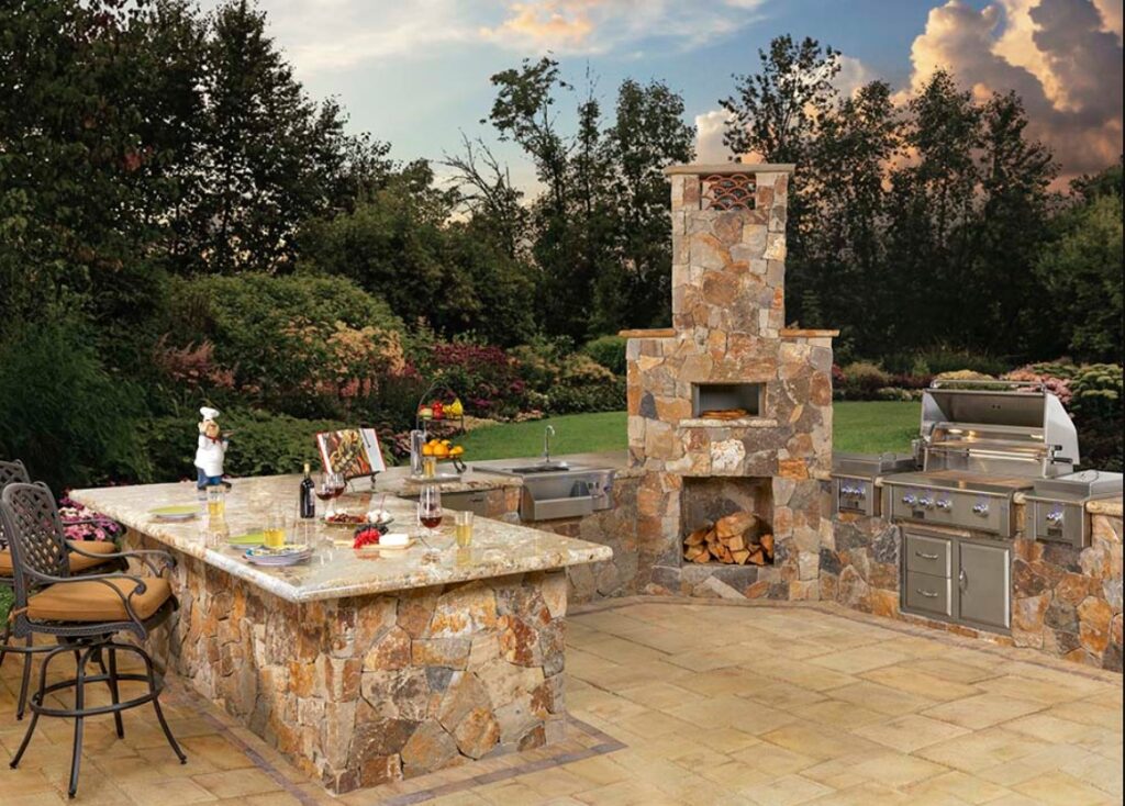 Stone patio with outdoor kitchen and seating area in a landscaped Toronto backyard