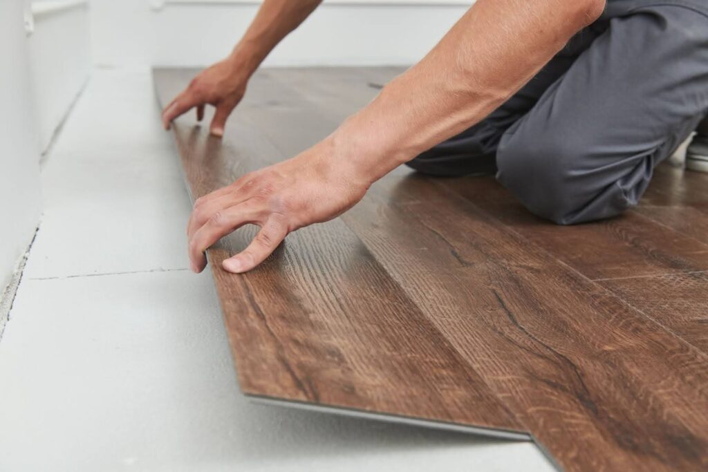 Underlayment being rolled out on a concrete slab.