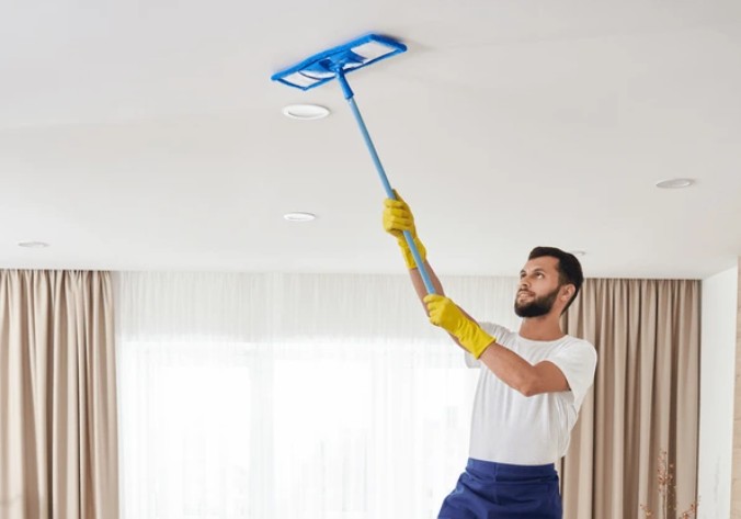 Cleaning panels with a duster.