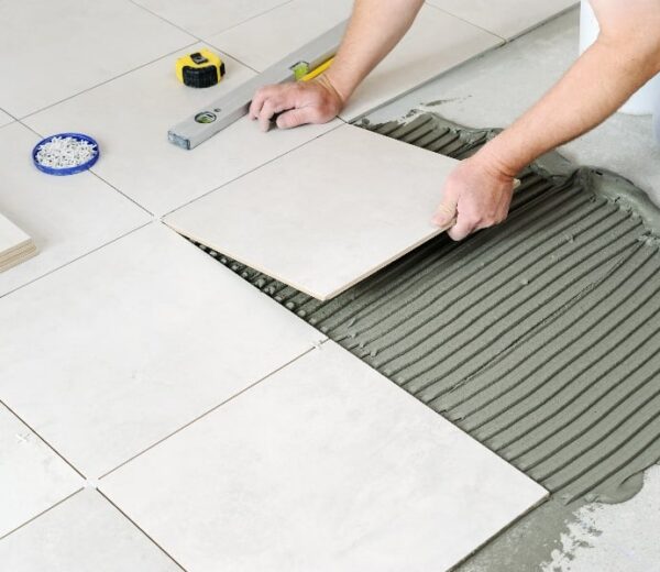 person laying ceramic tiles